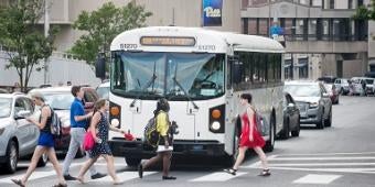 Students crossing the street by a bus