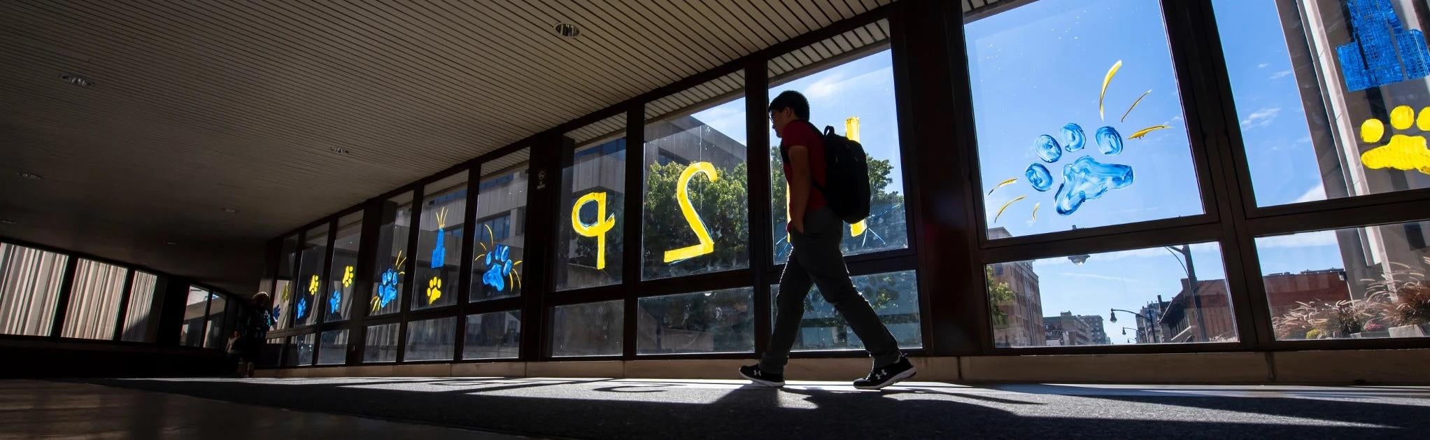 Student walking across skybridge